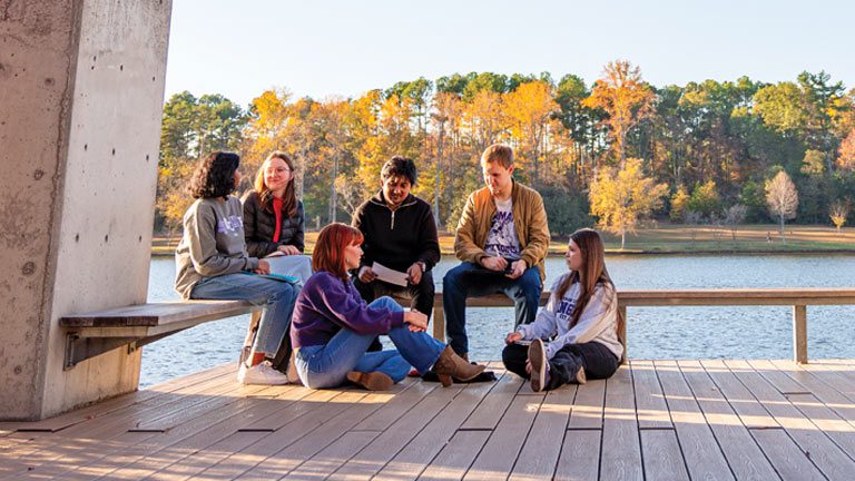 students gather on the dock by the furman lake